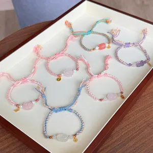 Handwoven ethnic style braided bracelet set featuring natural pink crystal and amethyst charms.