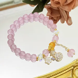 Gros plan detaille du bracelet de perles de cristal rose avec charmant pendentif de fortune.