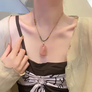 Collier pendentif en pierre d'agate naturelle style ethnique chinois gros plan détail.