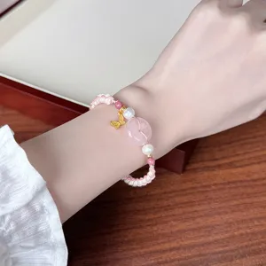 Chic rose quartz safety buckle woven bracelet, elegant pink crystal hand jewelry detail view.