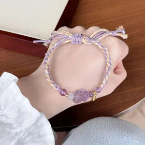 Close-up detail of woven pull-adjustable amethyst pixiu bracelet with pink crystal beads.