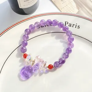 Vue détaillée du bracelet de perles en cristal violet scintillant avec pendentif renard.