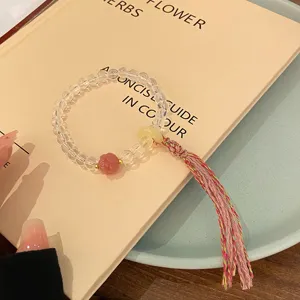 Gros plan sur un bracelet de perles en cristal blanc de style chinois avec beau pompon