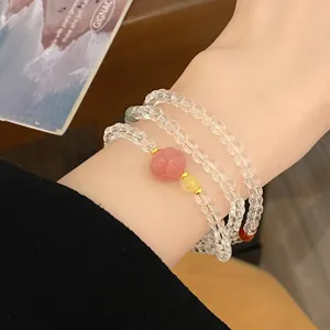 Gros plan d'un bracelet de perles en cristal blanc multicouche avec charm floral doux