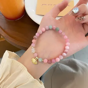 Detailed shot of the sweet macaron colored jade beaded bracelet with a cute gold lock charm.