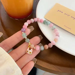 Detail shot of macaron colored jade beaded bracelet with cute metal fox mask pendant ornament.
