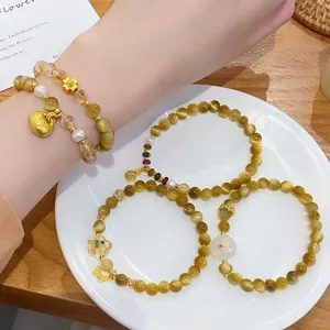 Detailed view of stylish natural crystal and tiger eye beaded bracelets with gold charms.