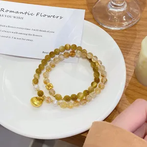 Yellow crystal tiger eye stone double layer bracelet detail view, elegant gold ingot pendant.