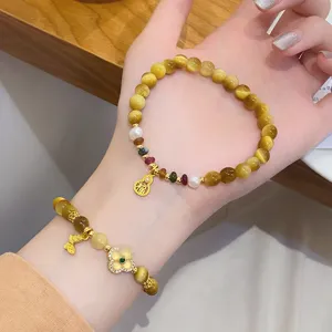 Chinese style natural yellow crystal and tiger eye gemstone bracelet with lucky gold charms.