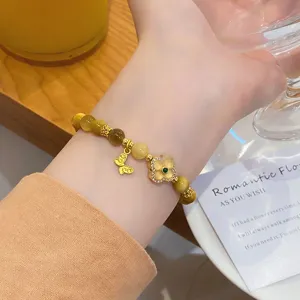Close-up detail of the luxury yellow crystal and tiger eye beaded bracelet with gold clover charm.