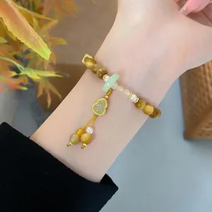 Detailed view of the new Chinese style yellow crystal and tiger eye bracelet with cute gourd charm.
