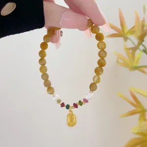 Detail view of natural yellow crystal tiger stone beaded bracelet with pearl and cute pendant.