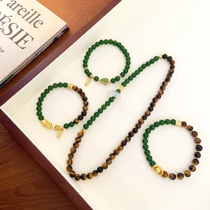 Gros plan détaillé de bracelets en œil-de-tigre et perles vertes avec des pendentifs dorés.