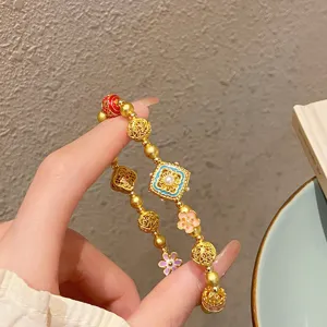 Vue de detail du bracelet de perles de fleurs dorees de style ethnique chinois, elegante.