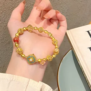 Gros plan détaillé du bracelet de perles dorées de style traditionnel chinois.