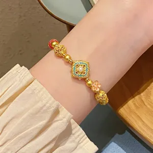 Vue détaillée de bracelet de perles en cuivre doré style chinois, design floral.