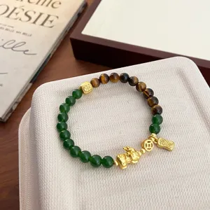 Vue détaillée du bracelet de style chinois en œil de tigre naturel et perles vertes.