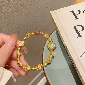 Bracelet de perles en or antique de style traditionnel chinois avec fleurs en émail et perles.