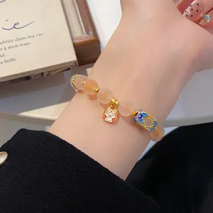 Vue détaillée du délicat bracelet en perles d'agate avec un charm chat chanceux et détails dorés.