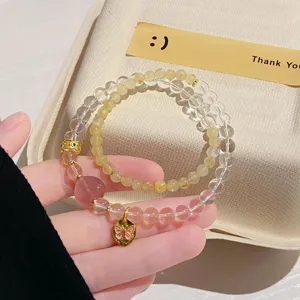 Detailed shot of crystal and rutilated quartz beaded bracelet with a cute butterfly pendant.
