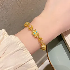 Gros plan sur le bracelet de perles d'or ancien style traditionnel chinois avec des fleurs.