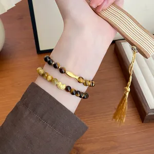 Nahaufnahme von naturgegebenen gelben Tigerauge Edelstein Perlen Doppelarmbändern mit Gold.