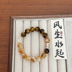 Vue detaillee du bracelet en perles de quartz rutiles jaunes et oeil de tigre.