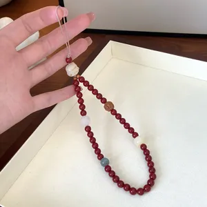 Pendentif de téléphone chat chanceux style chinois avec perles rouges, vue de détail élégante.