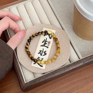Detailansicht des natürlichen gelben Tigerauge Armbands, feine Edelsteinperlen mit Goldanhänger.