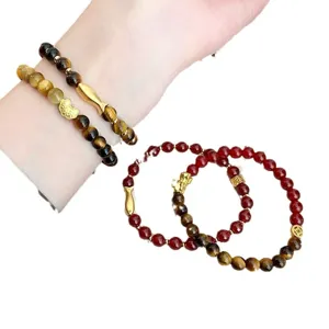 Natürliches Tigerauge und roter Achat Armband mit goldenen Glücksanhängern für Damen.
