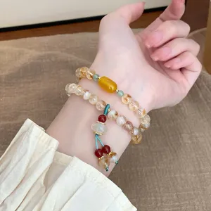 Détail en gros plan du bracelet de perles en cristal naturel avec pompon pour femmes style.