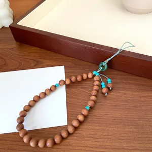 Magnifique bijou de téléphone en perles de bois avec détails turquoise et pendentif en jade.