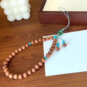 Vue détaillée du pendentif de téléphone en perles de bois de santal avec anneau de jade.