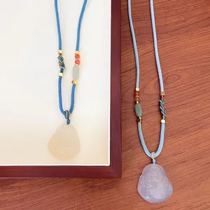 Detailed view of Chinese style natural agate Buddha pendant long sweater chain with blue cord.