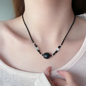 Vue détaillée du collier pendentif en perles d'obsidienne noire avec cordon tressé.