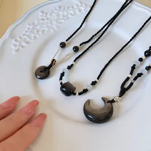 Colliers pendentifs en obsidienne naturelle avec cordes tressées, styles chat et lune.