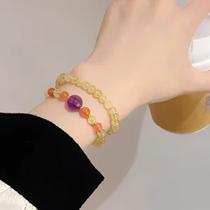 Detail shot of natural crystal beaded double-loop bracelet with gemstone and metallic accents.