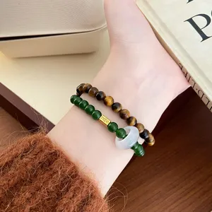 Vue détaillée de bracelet en œil de tigre jaune naturel et perles vertes avec anneau.