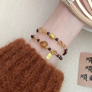 Close-up detail of double-layer crystal gemstone beaded bracelet with gold Fu charm.