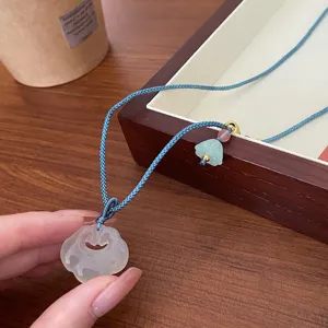 Chinese style white agate ruyi lock pendant necklace with blue braided cord and delicate beads.