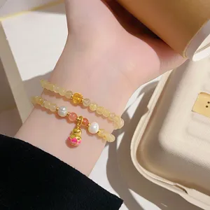 Close-up detail of double-layer beaded bracelet featuring citrine, pearls, and gourd charm.
