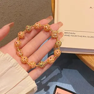 Gros plan détaillé du bracelet de perles de fleurs dorées de style ethnique chinois.