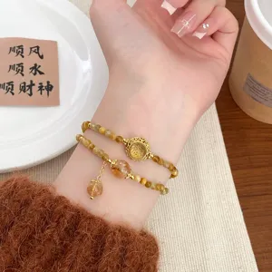 Exquisite double-layer natural crystal bracelet with delicate golden hollow pendant for women.