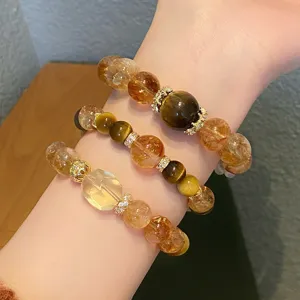Détail en gros plan de bracelets en cristal de pierres précieuses avec citrine et œil.