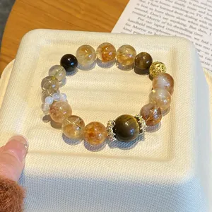 Détail du bracelet en cristal naturel avec citrine, quartz fumé et détails dorés.
