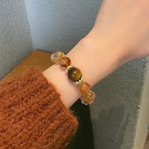 Gros plan détail montrant un superbe bracelet cristal naturel multi-trésors au poignet.