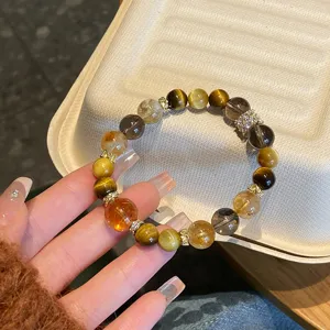 Gros plan détaillé du bracelet en cristal de citrine naturelle et quartz fumé au poignet.