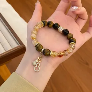 Vue de détail d'un bracelet en pierres précieuses de cristal naturel avec pendentif gourde.