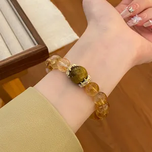 Gros plan d'un bracelet de perles en cristal de citrine naturelle et œil-de-tigre avec détails.