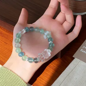 Mint green fluorite beaded bracelet detail view featuring a cute crystal bear charm.